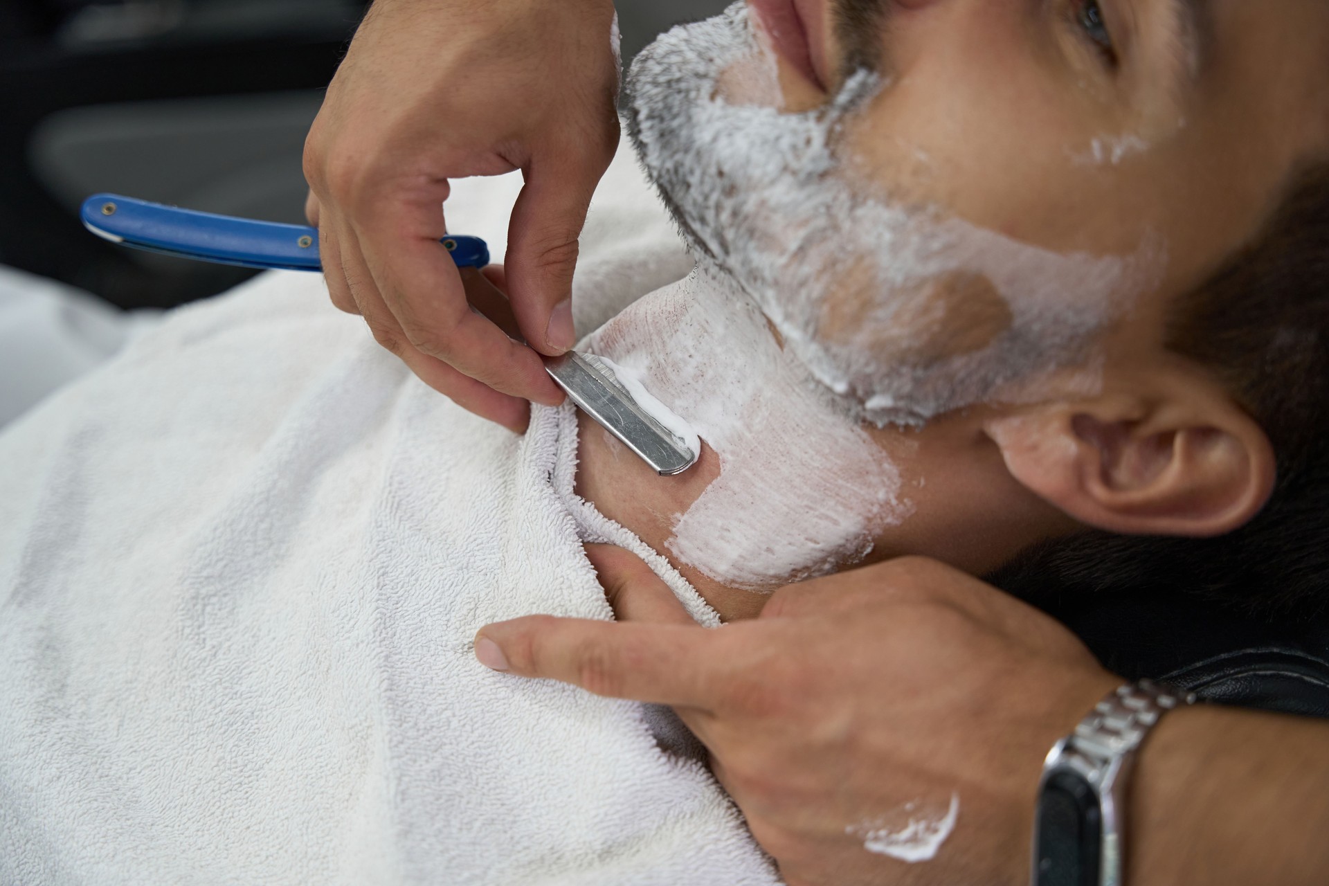 Laid-back gentleman with face covered in foam getting a shave