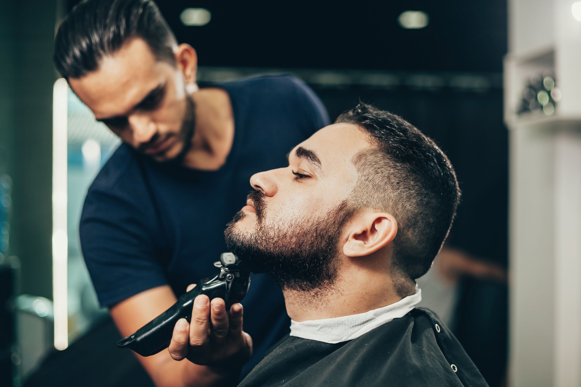 Client during beard and hair grooming in barber shop